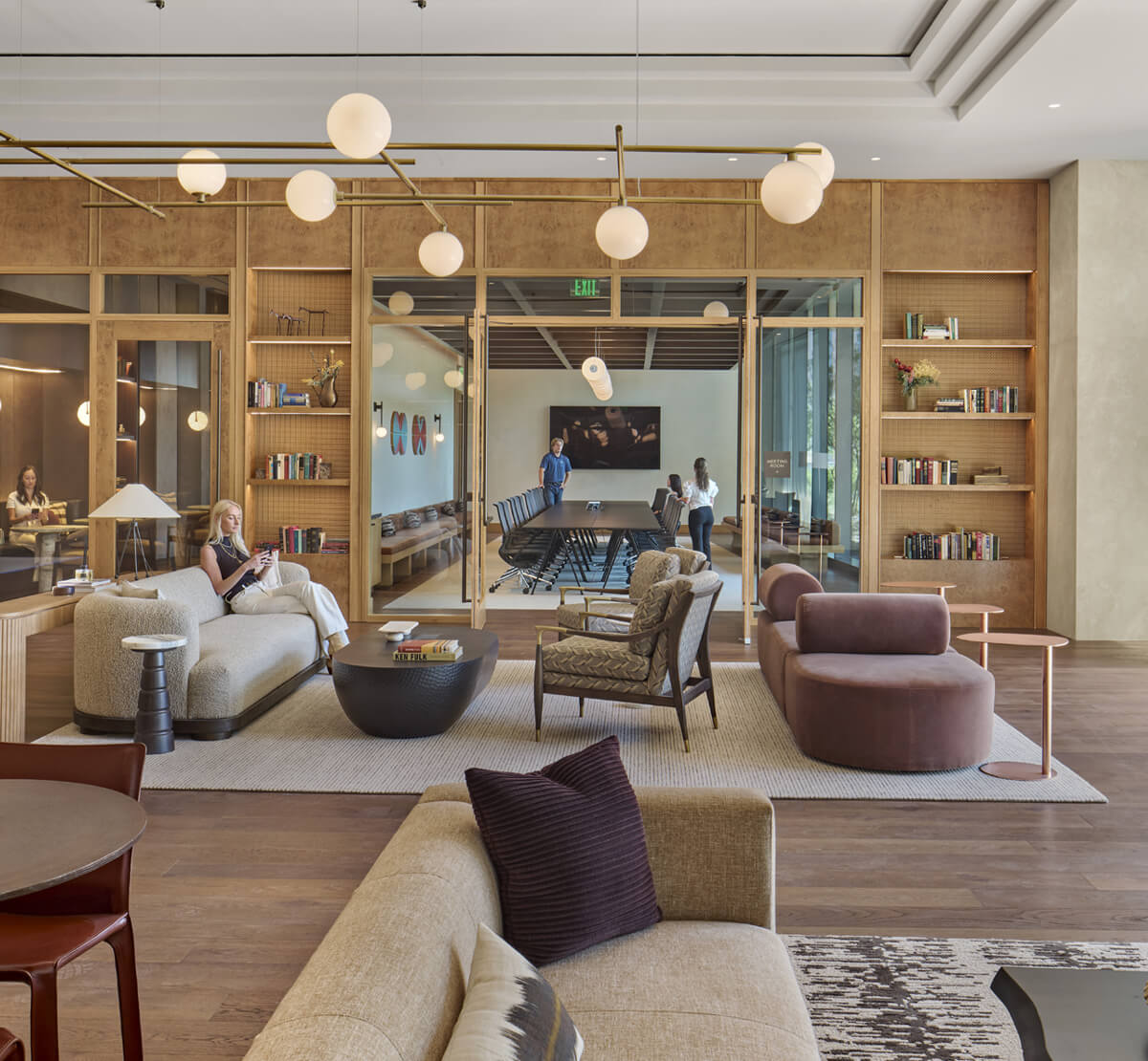 Two coworkers chat in an empty conference room with expansive view