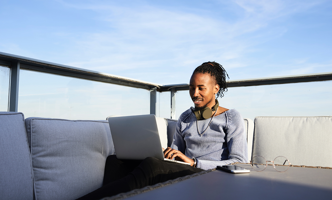 African American man on his laptop on the rooftop terrace
